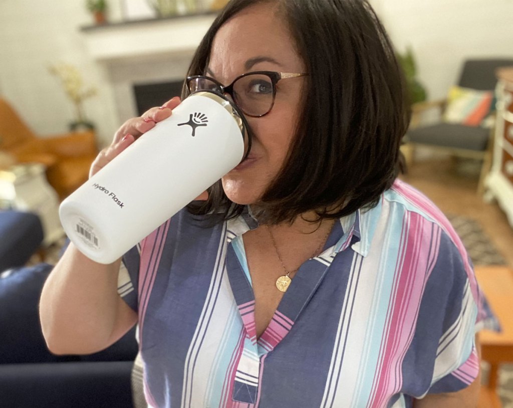 woman drinking out of white hydro flask tumbler