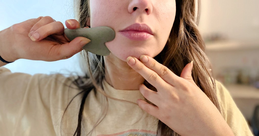 girl holding gua sha to face