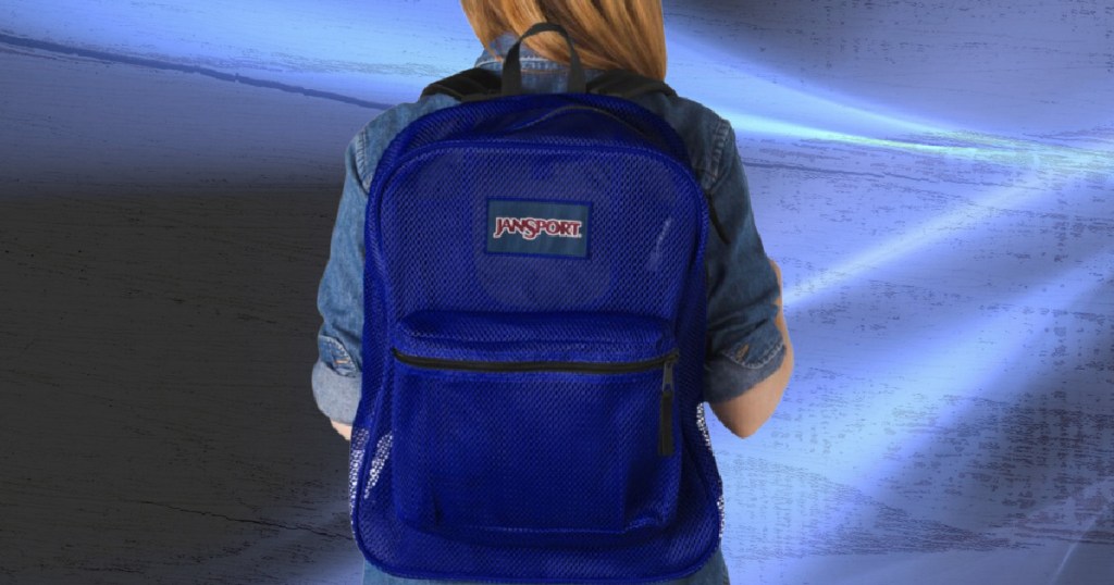 woman wearing blue Jansport backpack with blue background