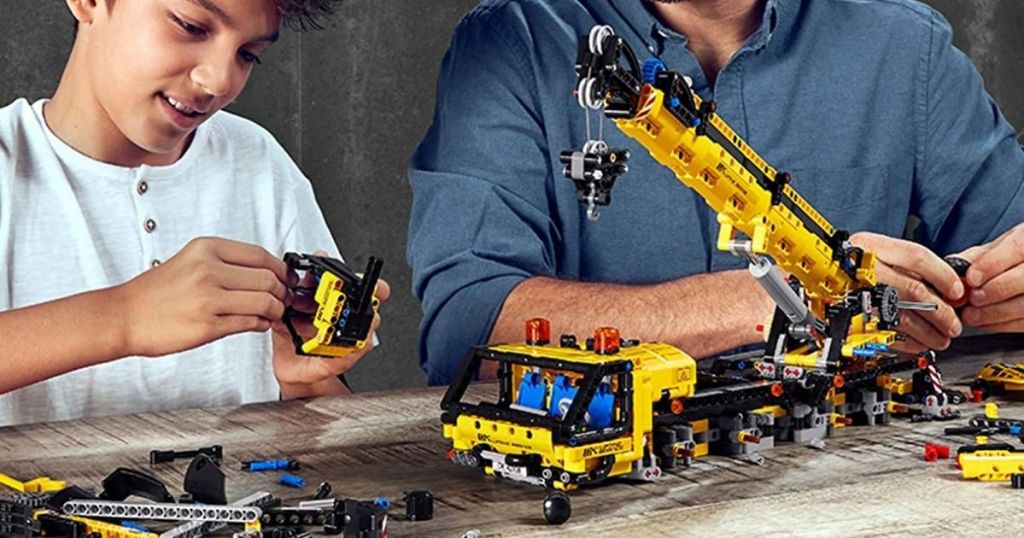 two people putting together a LEGO crane