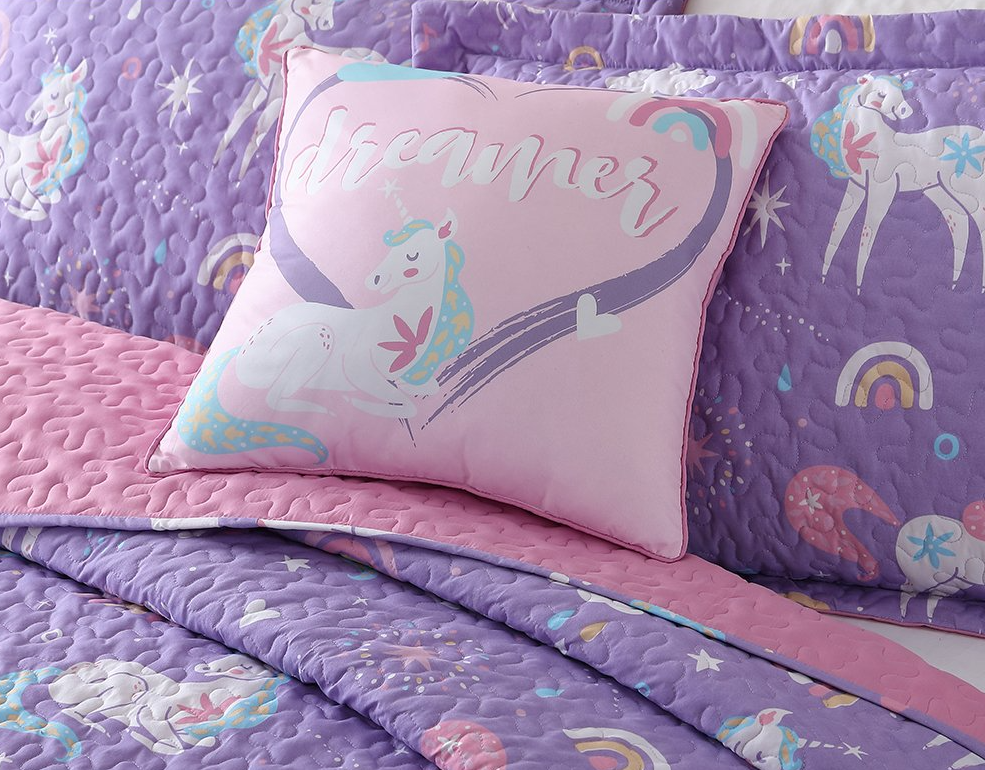 bed with a unicorn pillow on it