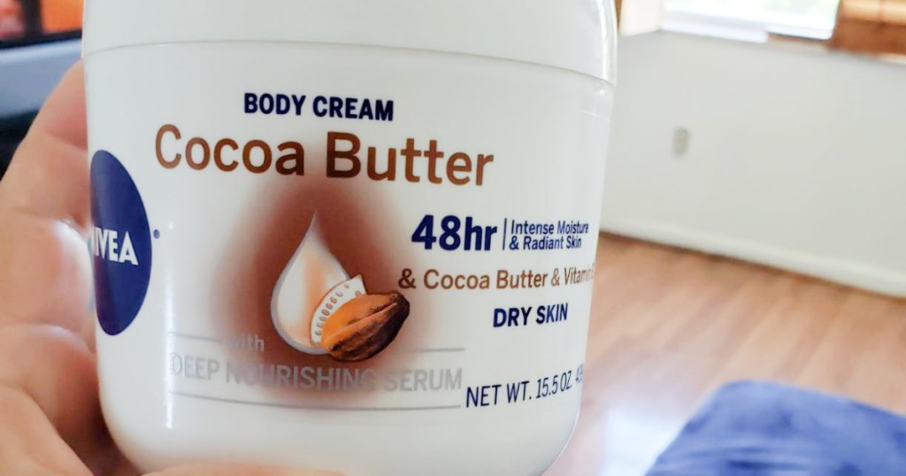 hand holding jar of cocoa butter cream