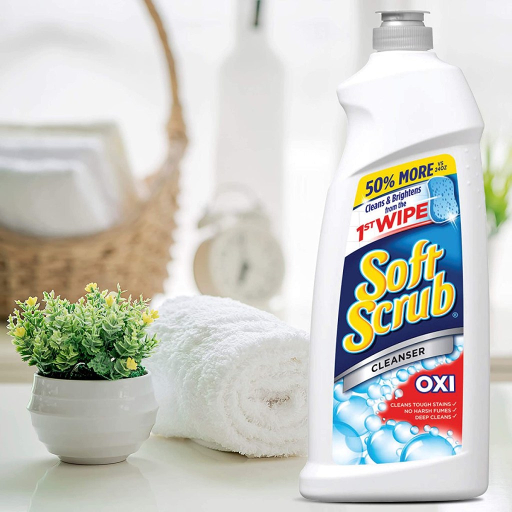 large bottle of bathroom cleaner on counter near rolled towel and basket
