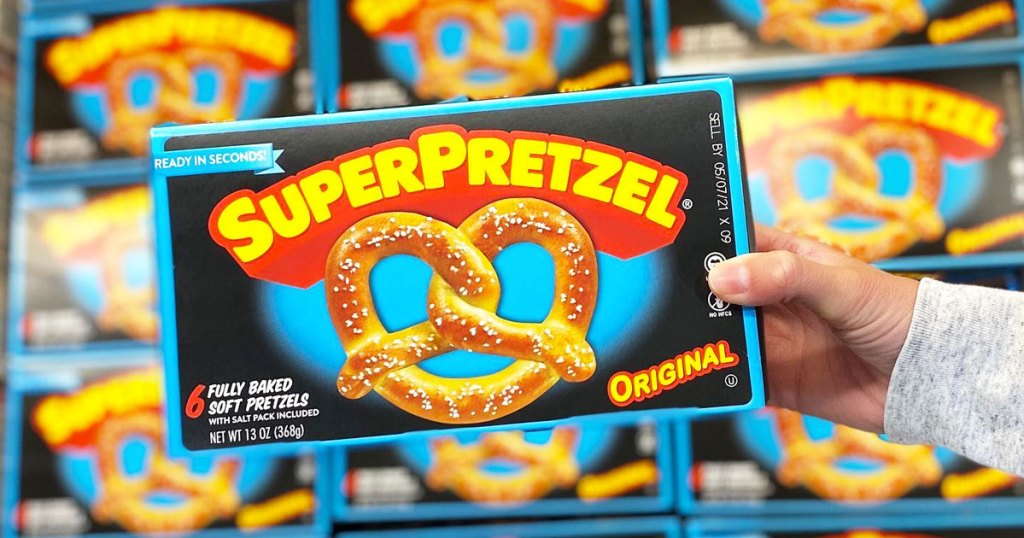 person holding box of superpretzel soft pretzels