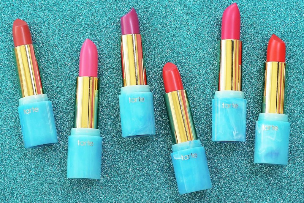 multiple tubes of tarte lipstick on blue glitter background