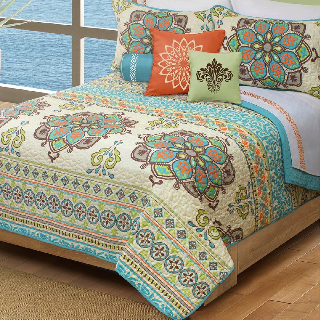 colorful quilt set on a bed in a bedroom near a window