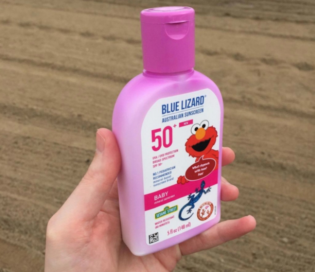 hand holding a pink bottle of blue lizard sunscreen