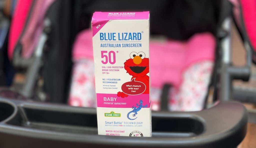 box of blue lizard sunscreen sitting on pink stroller