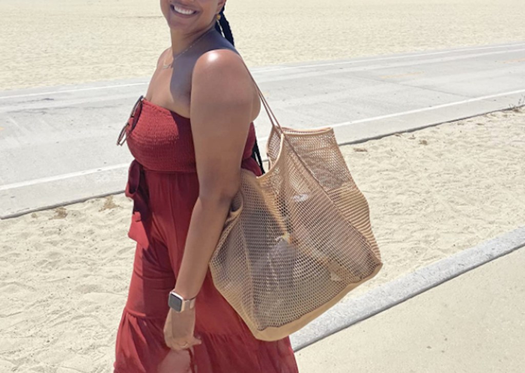 woman standing in sand with mesh tote bag on shoulder