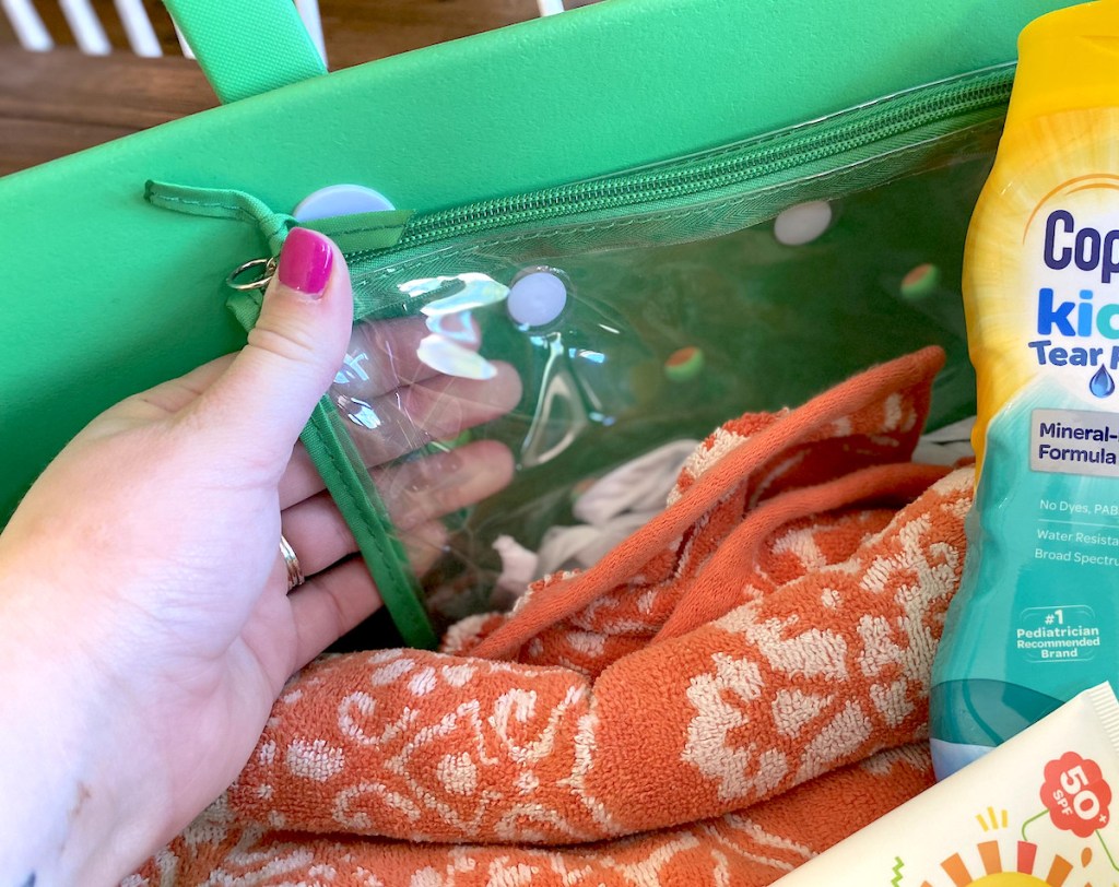 hand pulling clear bag off side of green tote
