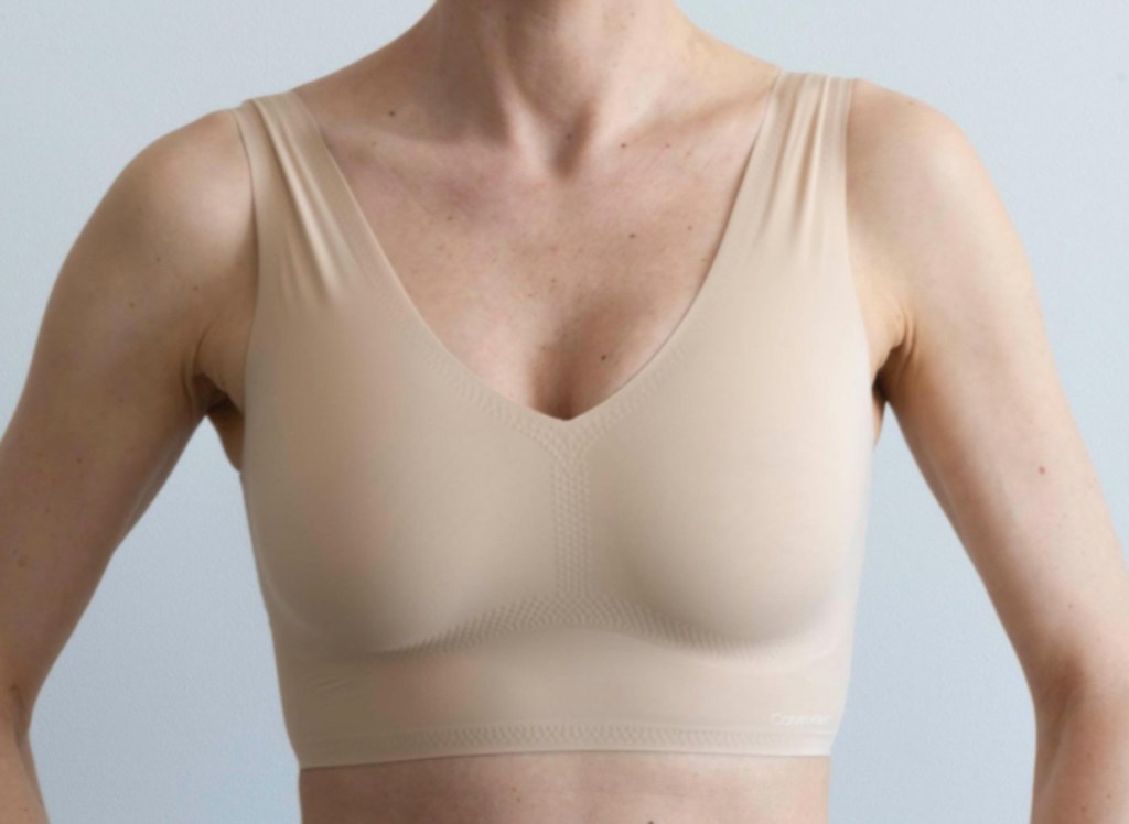 close up of woman wearing tan colored sports bra