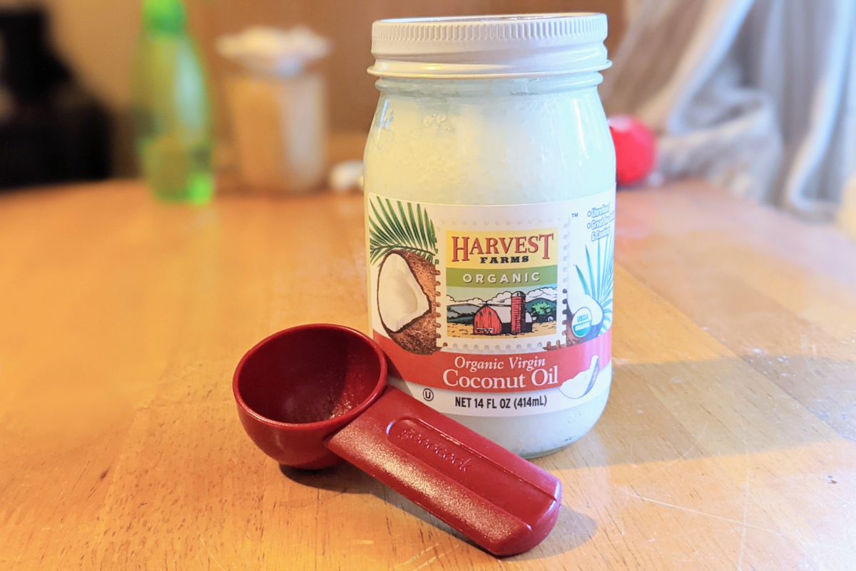 coconut oil jar and red tablespoon on table