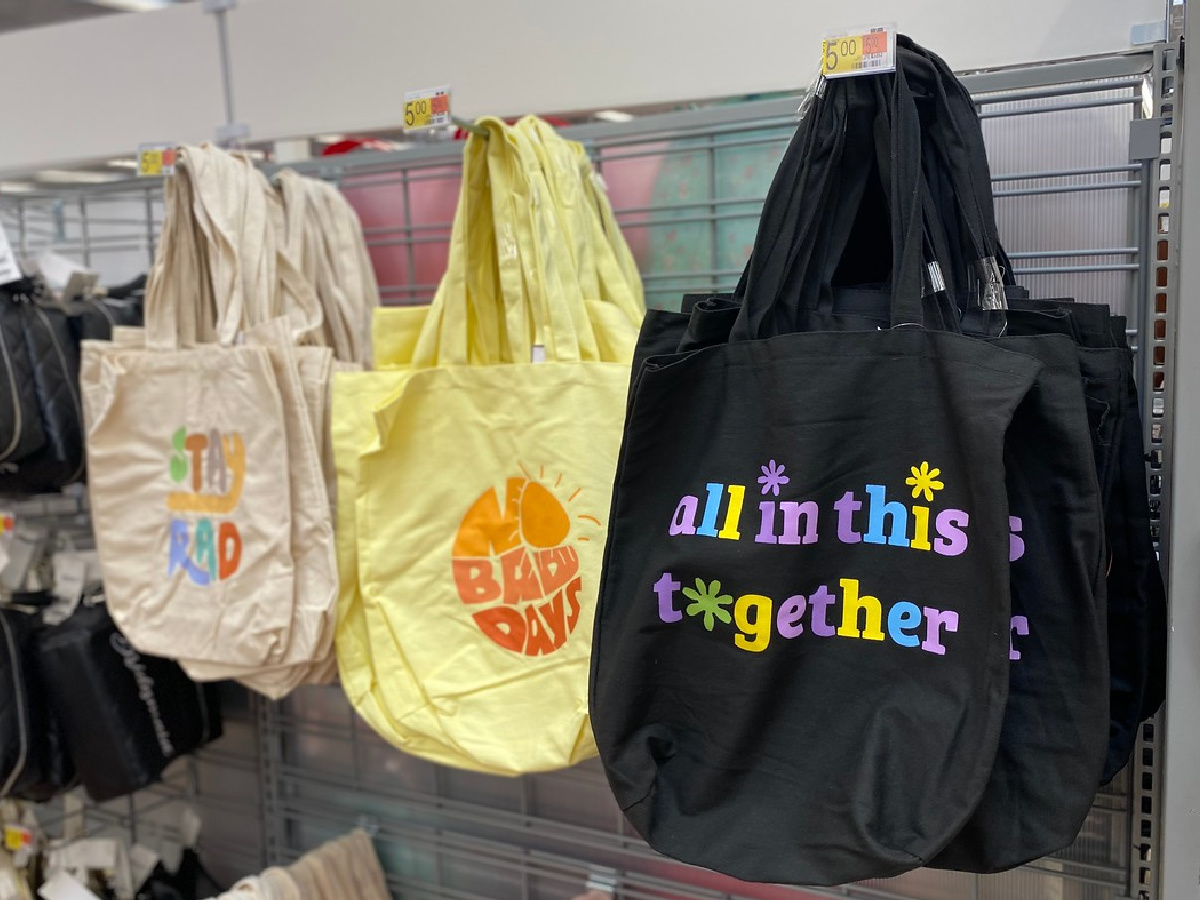 store display with three tote bags hanging up