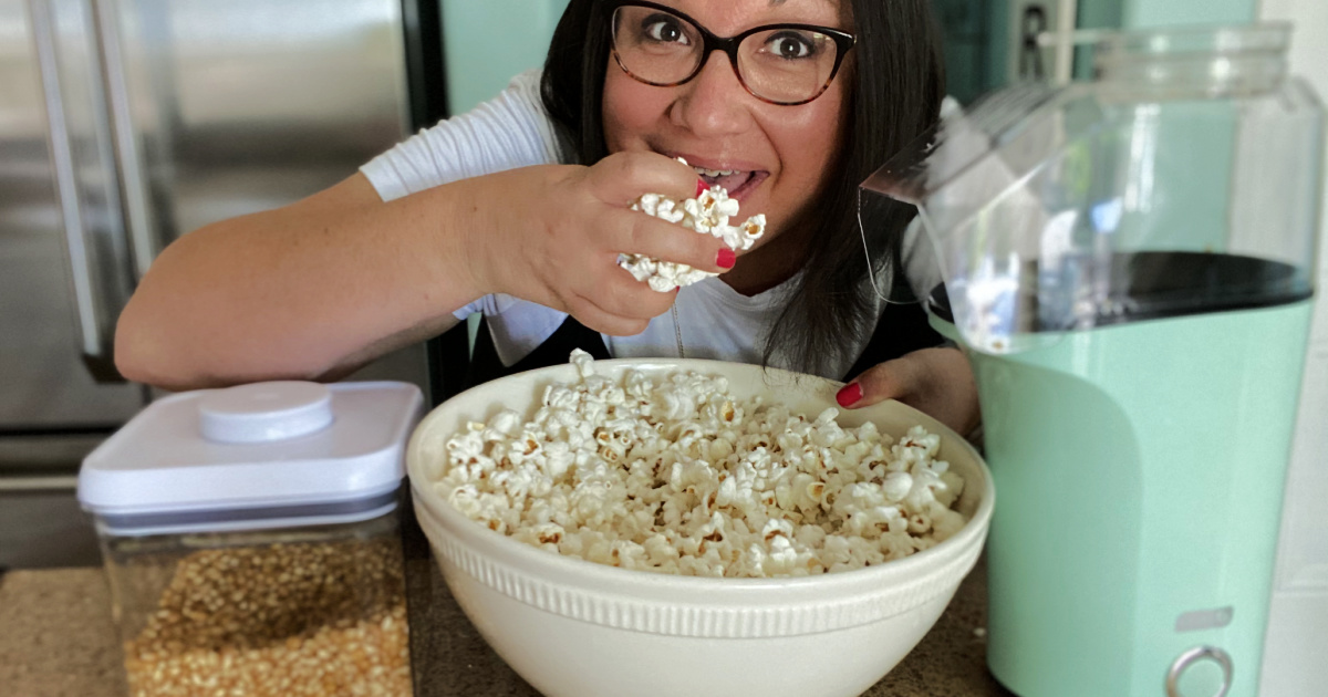 woman eating popcorn with dash popcorn machine
