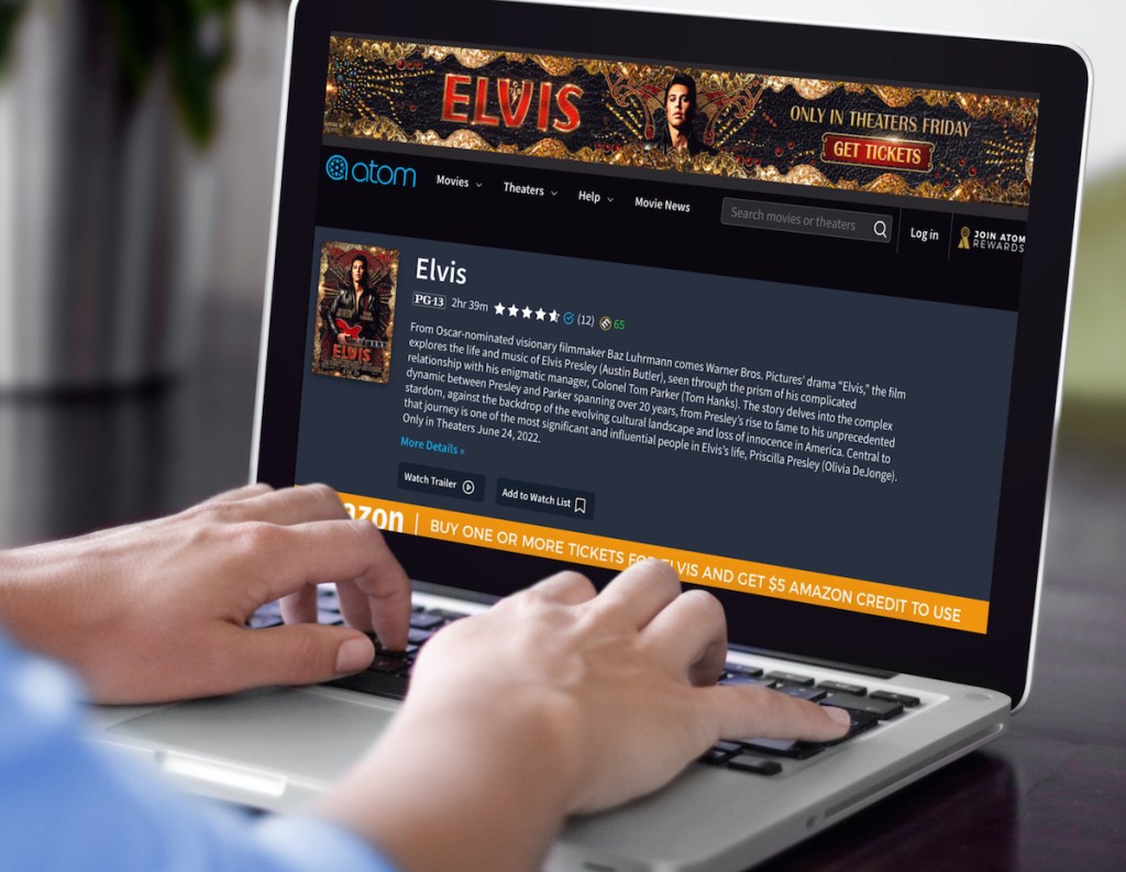 hands typing on laptop with new elvis movie on screen