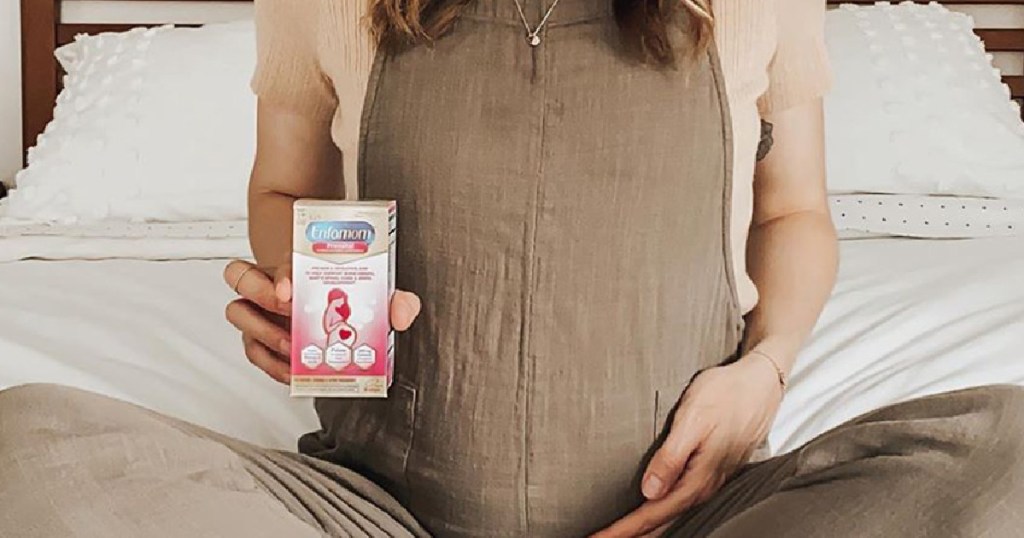 pregnant woman holding a box of vitamins
