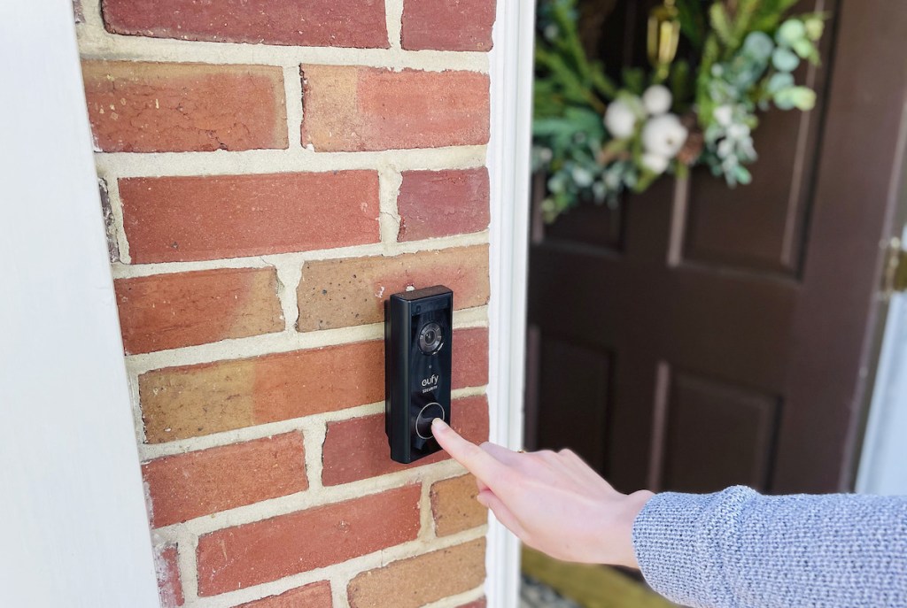 finger pushing on eufy video doorbell