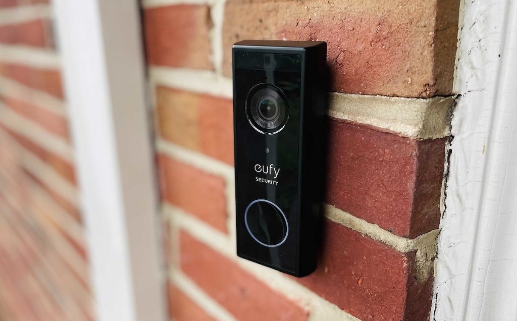 close up of black eufy video doorbell on brick house