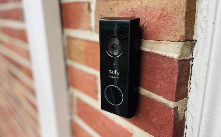 close up of black eufy camera doorbell on brick house