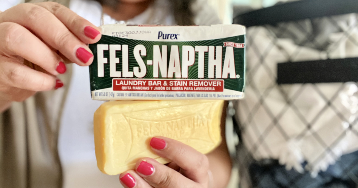 holding up two bars of fels-naptha soap bars