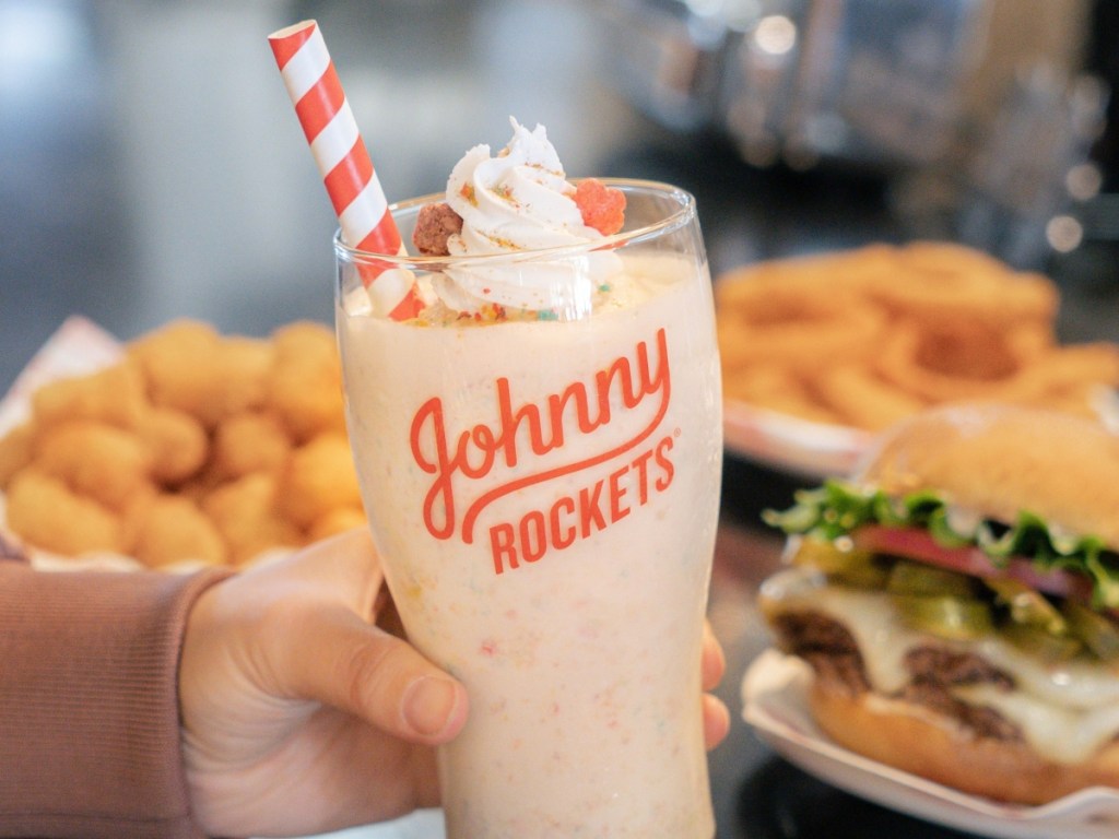 holding a milkshake in a Johnny Rockets glass
