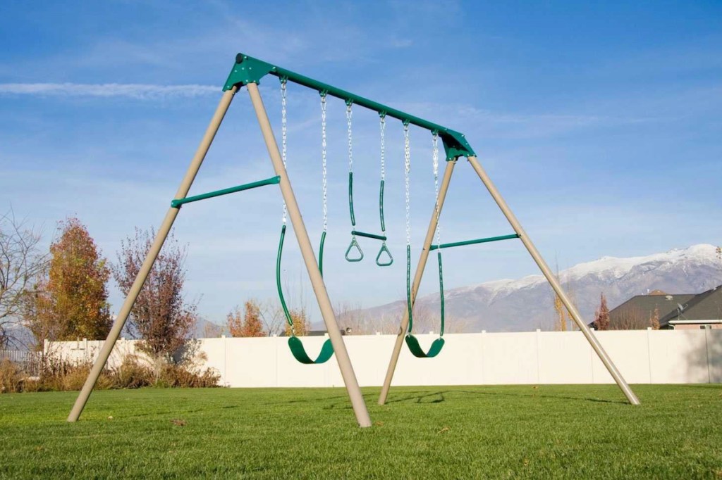 metal swing set in grass outside