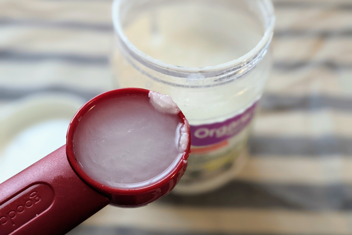tablespoon of coconut oil in front of container