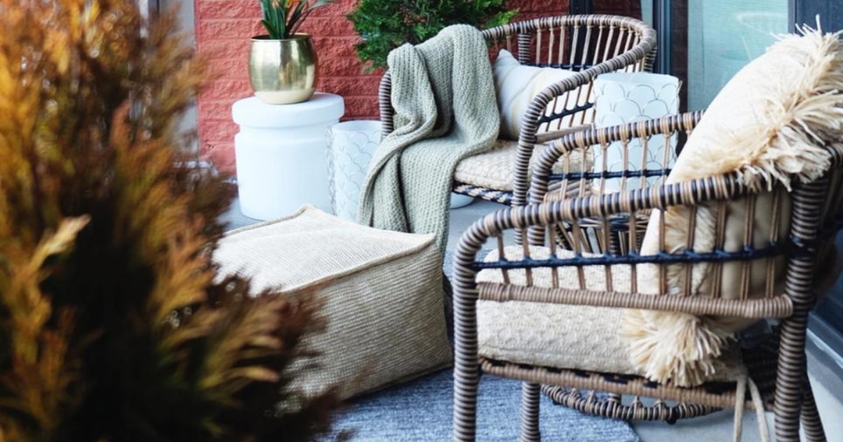 two patio chairs outside on a porch next to bushes