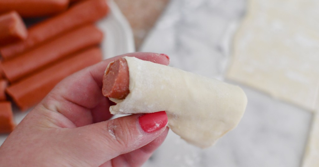 rolling a a hot dog in puff pastry 