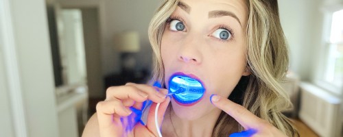 woman holding blue light in mouth