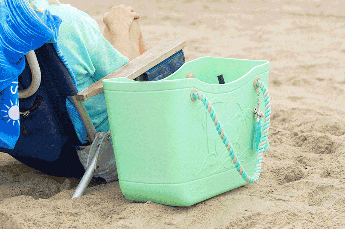mint green rubber beach bag in sand 