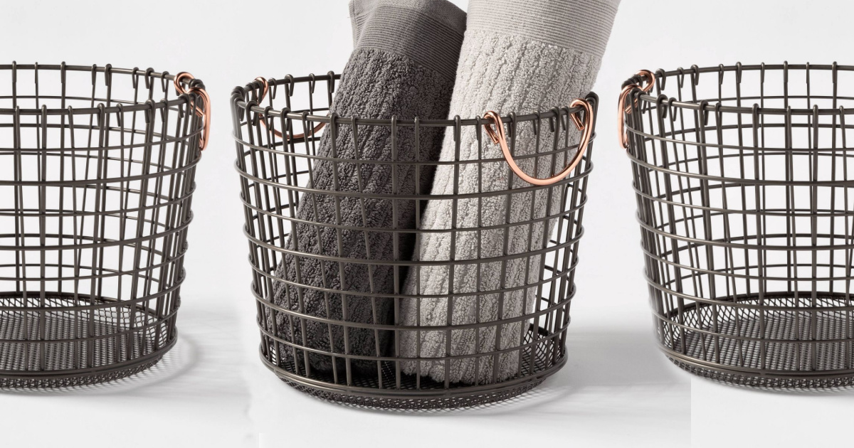 three wire baskets in a row, one with rolled up towels
