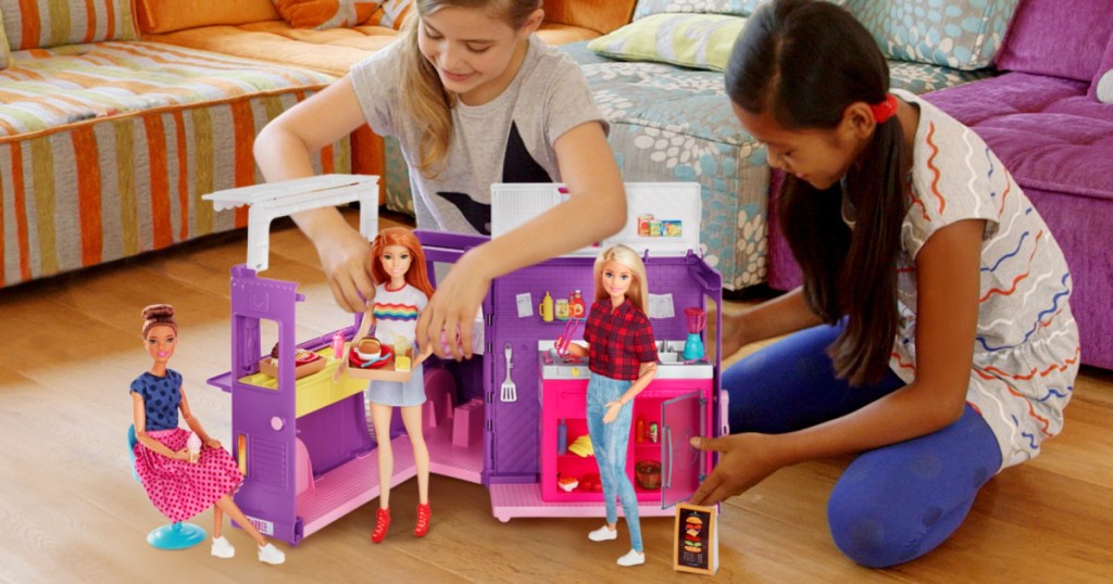 girls playing with a food truck themed Barbie set