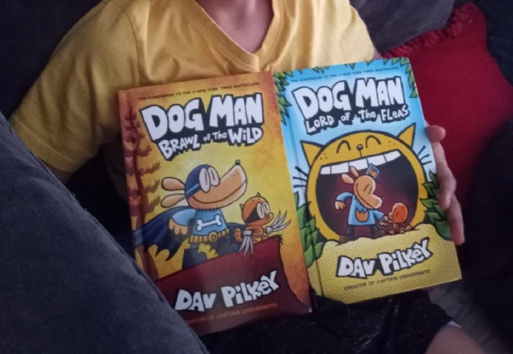 child holding two dog man hardcover books