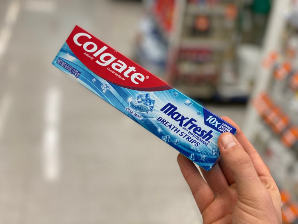 hand holding box of toothpaste in store