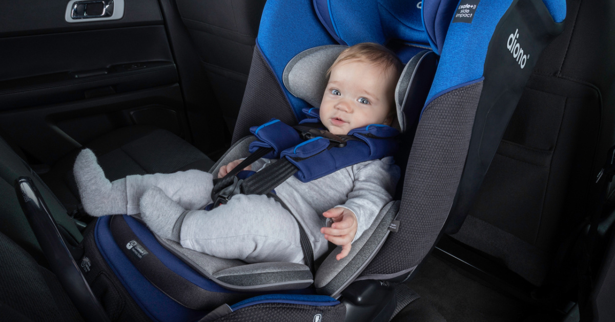 baby boy strapped into the harness of a blue and black car seat rear facing