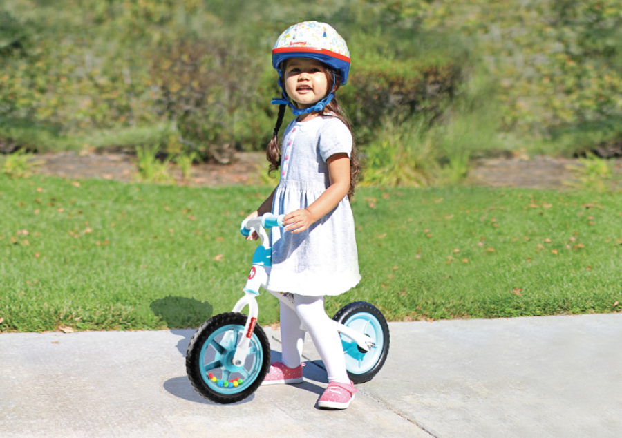 girl riding Fisher Price lightweight Balance Bike on sidewalk