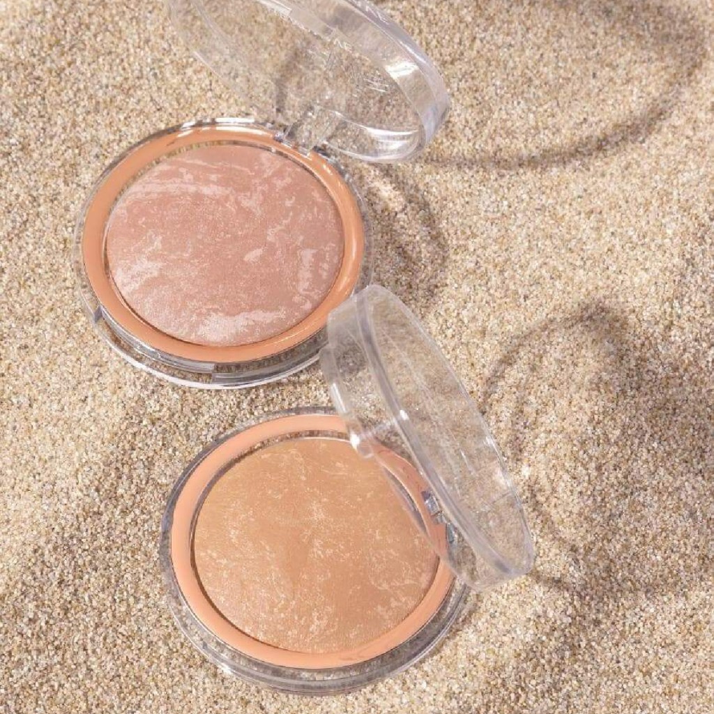 two containers of highlighter in sand