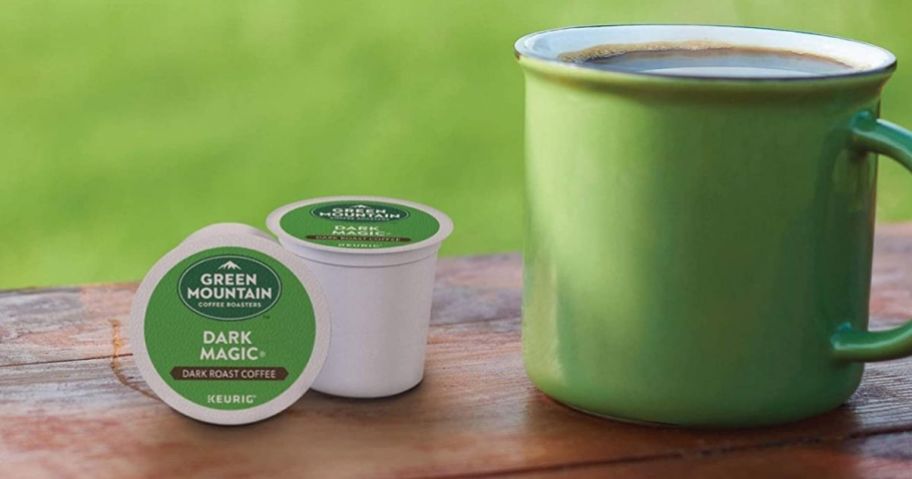 Green Mountain Dark Magic k-cups next to a cup