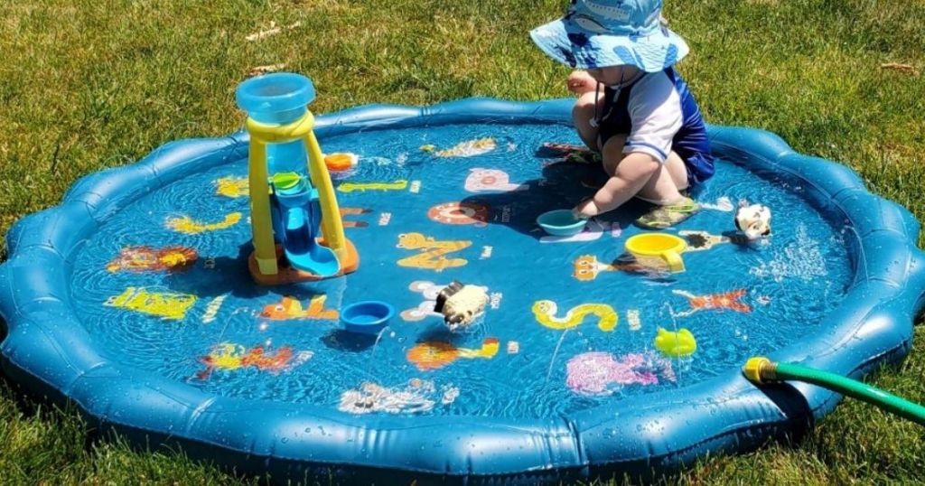 baby playing in a sprinkler