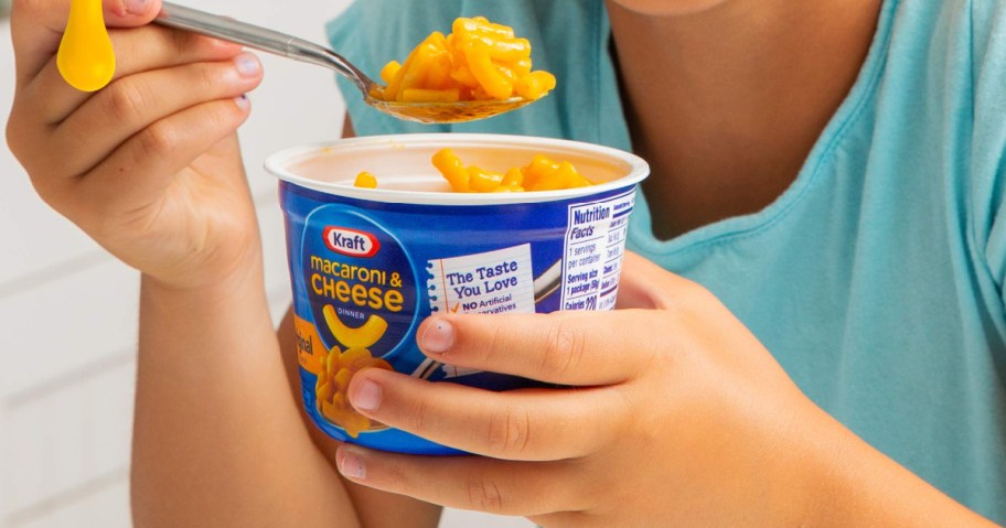 childholding kraft mac and cheese cup
