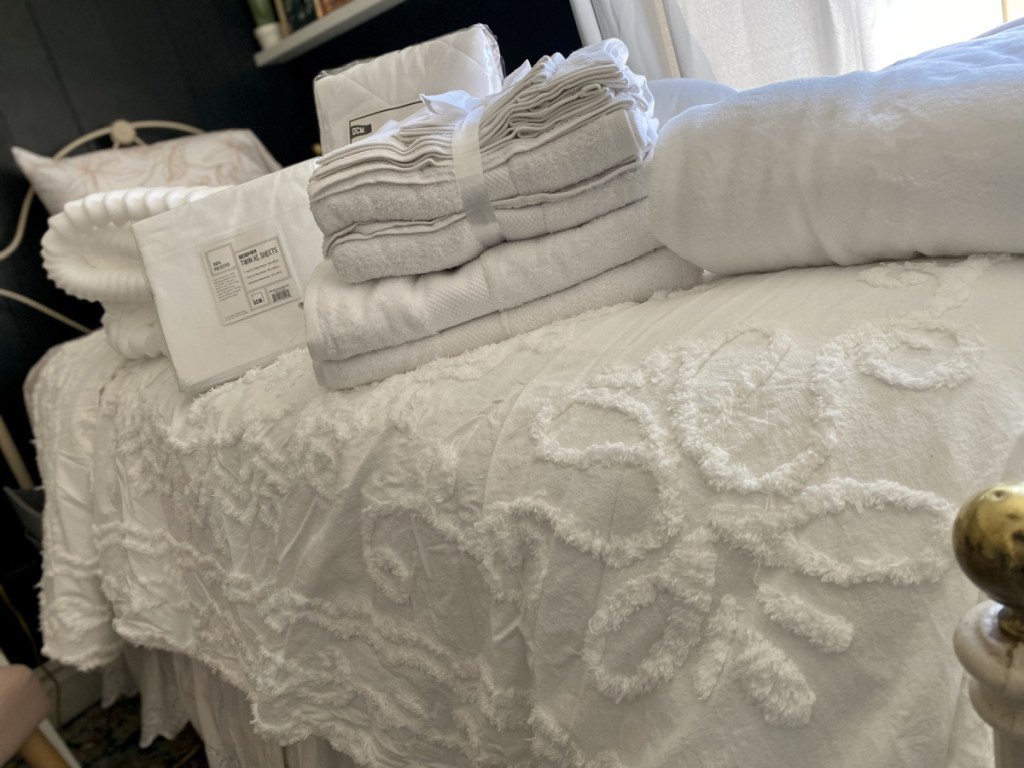 White comforter topped with bedding and bath items