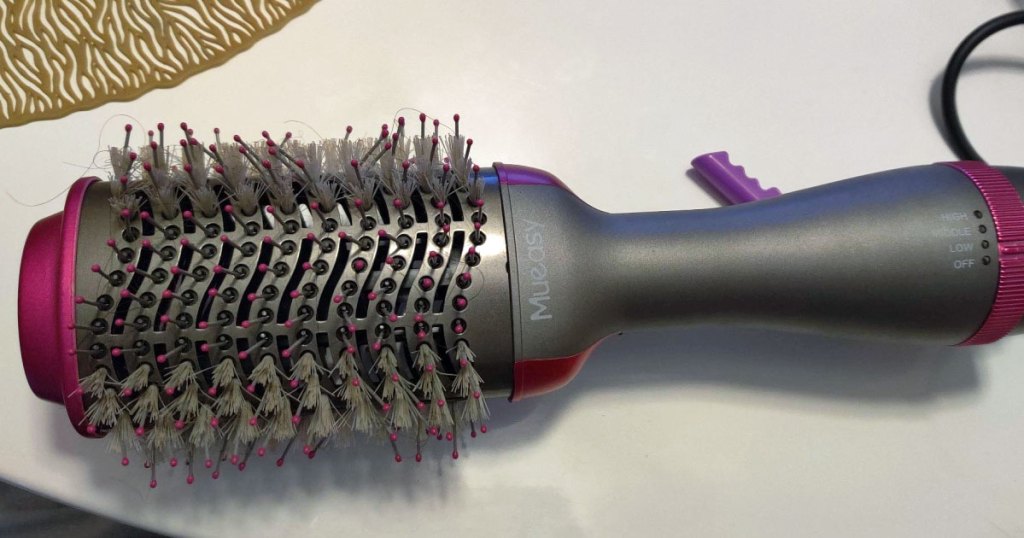 grey and pink hair dryer brush on white table