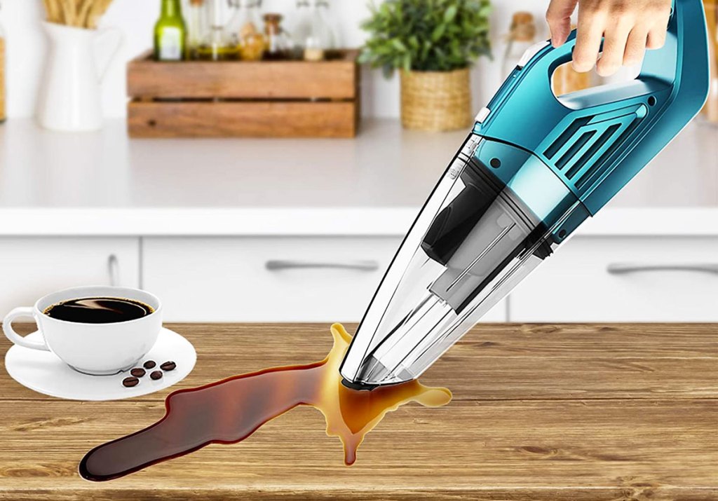 handheld vacuum cleaning up spilled coffee