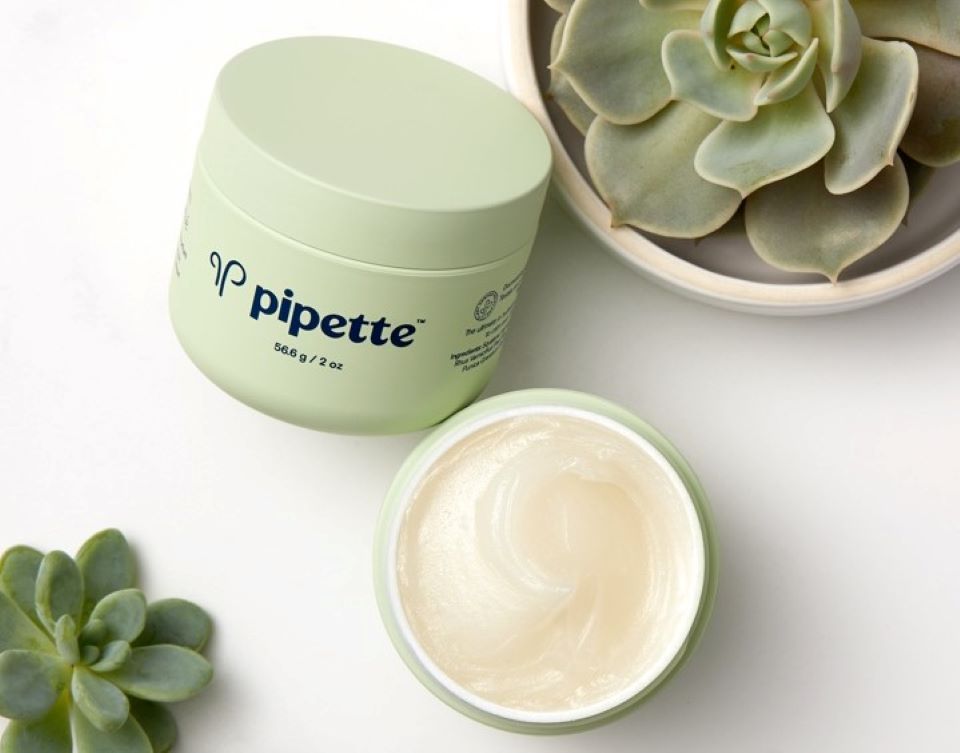 Pipette baby balm by a plant