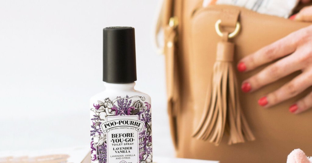 poo pouri bottle with a bag and hand behind it