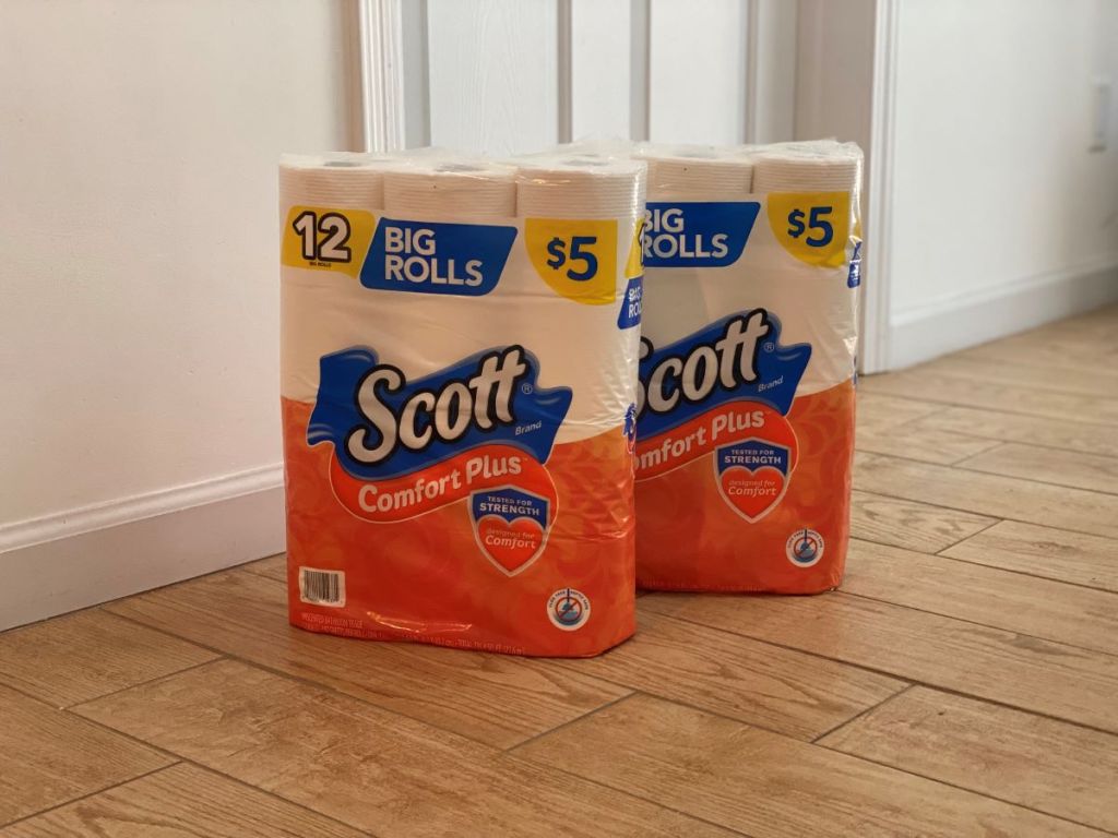 two packages of toilet paper on the floor