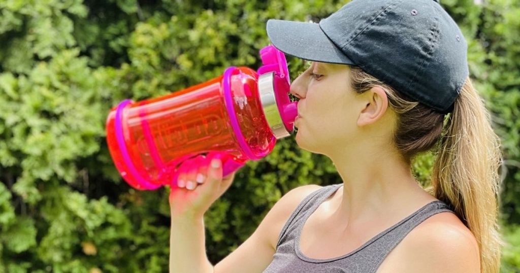 woman drinking out of a water bottle