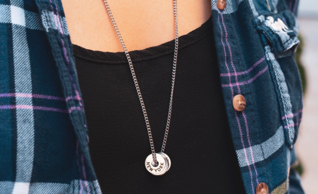 person wearing a necklace with tokens on it