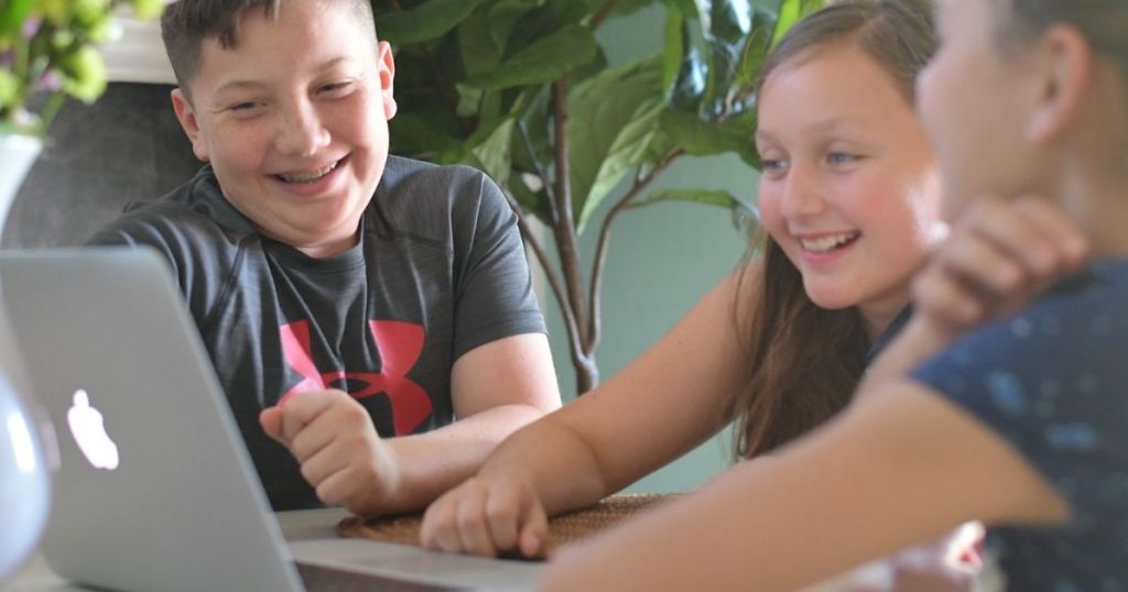 kids watching and smiling at computer screen
